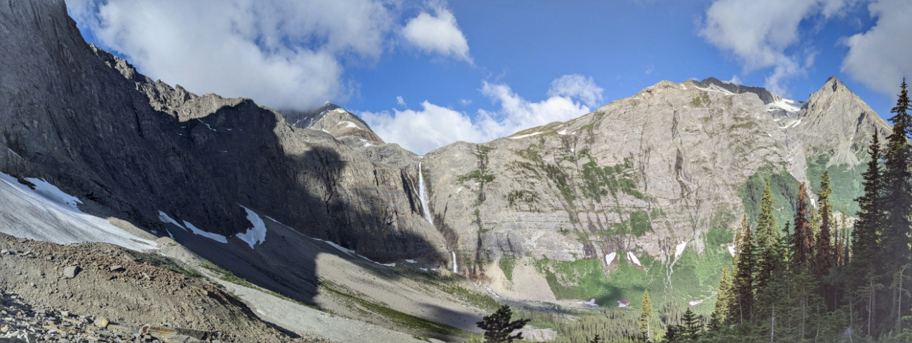 Helmet Falls under Helmet Mountain with Sharp Mountain above the trees.